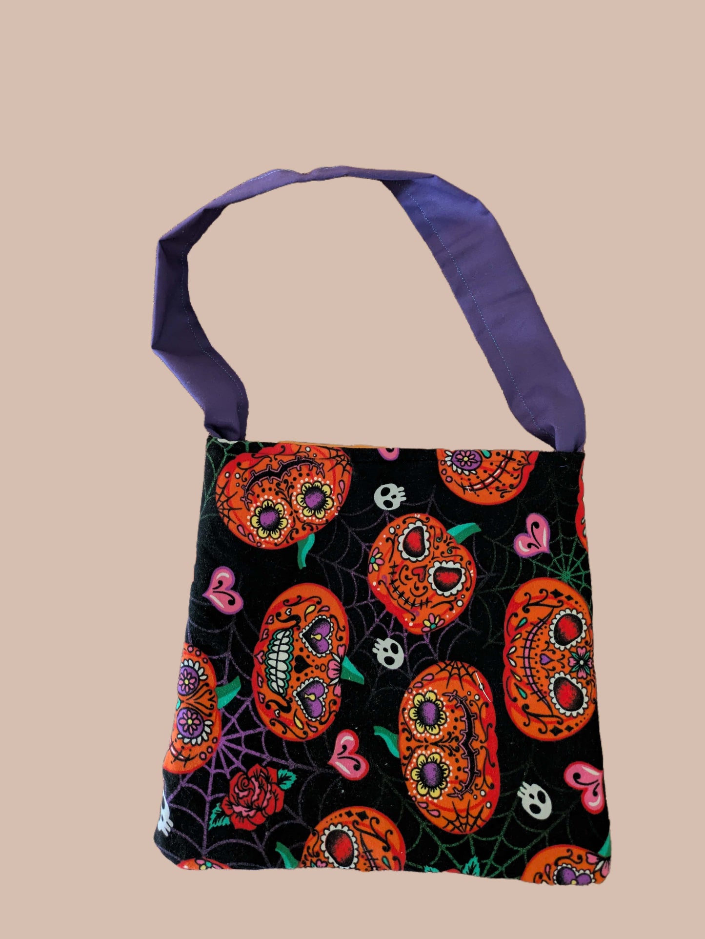 Tote bag with Halloween-themed design on a beige background